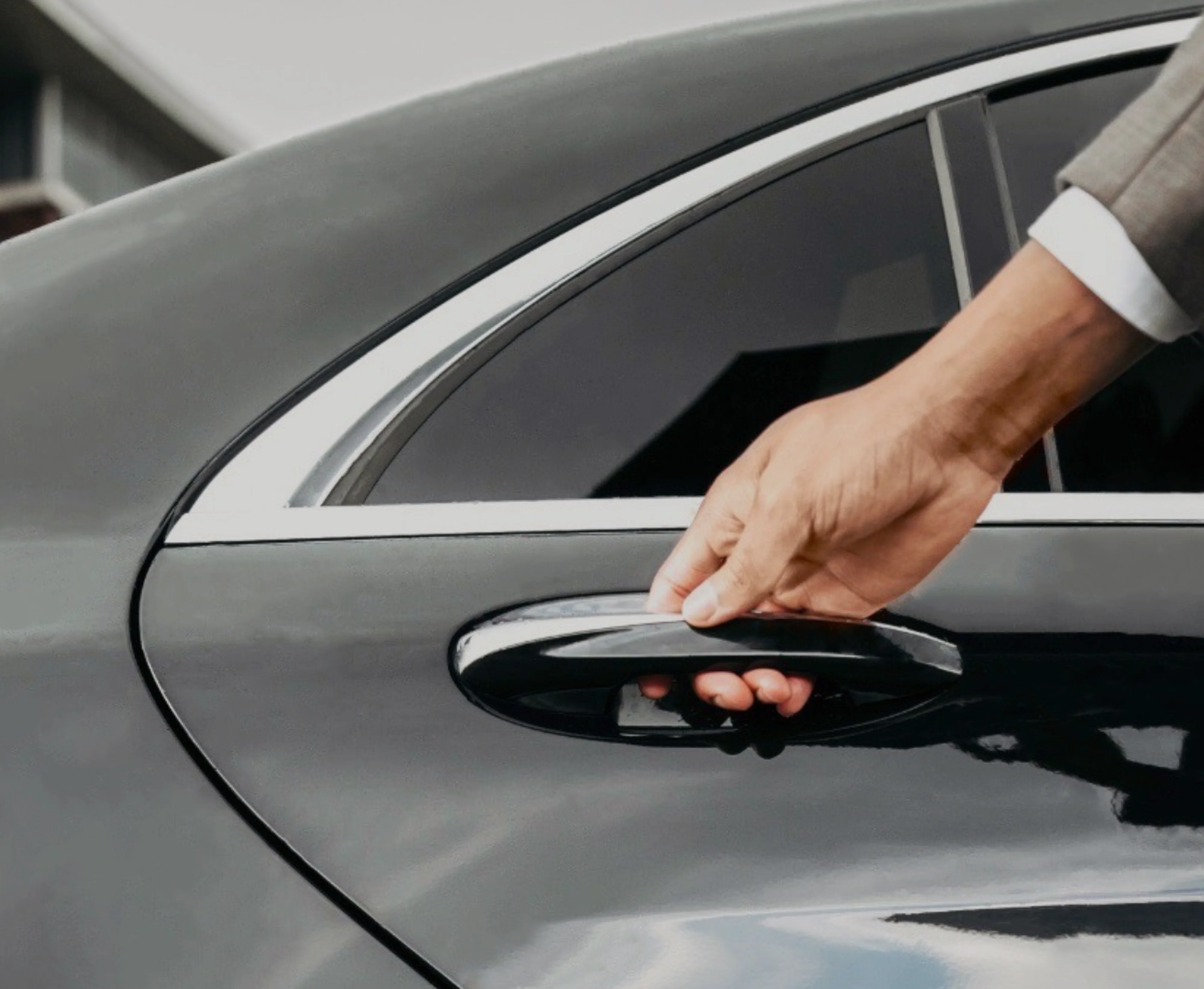 Водитель открывает дверь автомобиля представительского класса